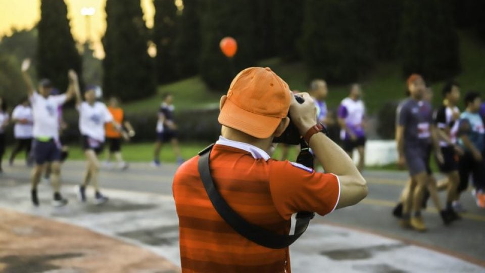 photographer taking a photo during group people running a marathon